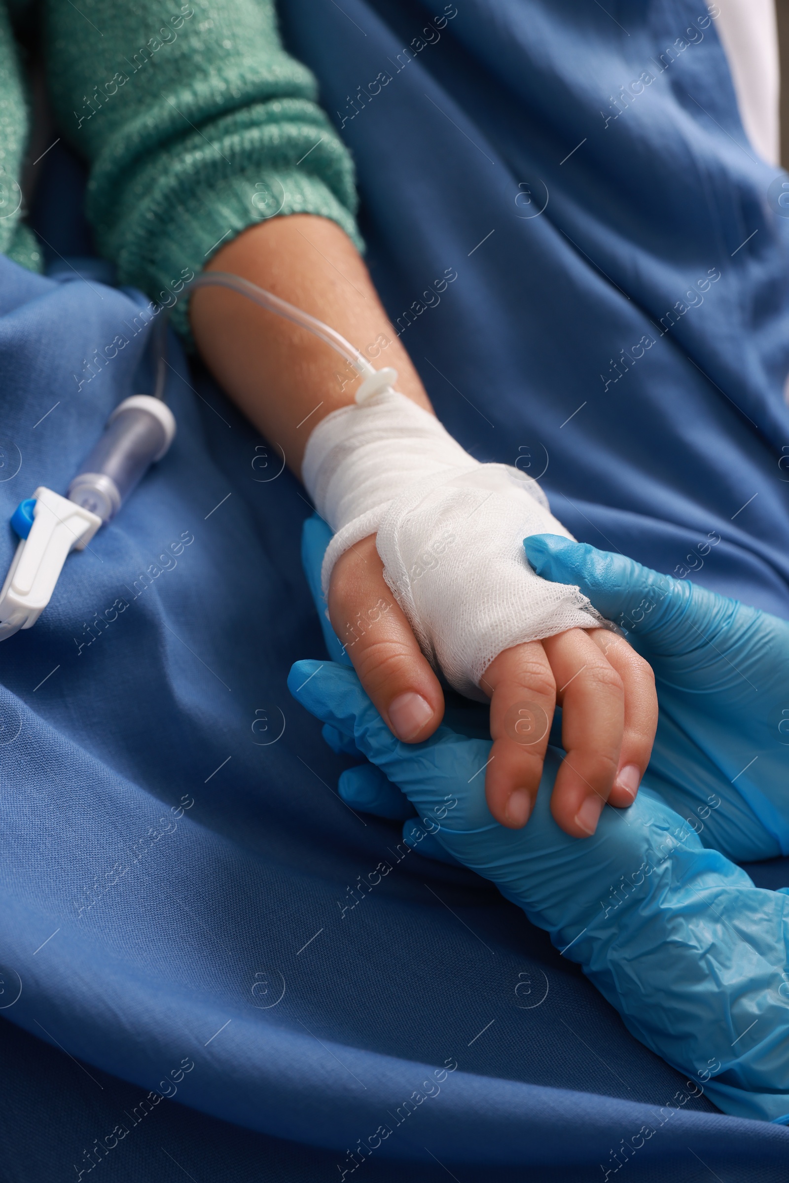 Photo of Doctor and child with IV drip in hospital, closeup