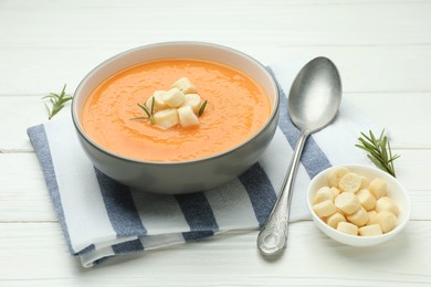 Photo of Delicious sweet potato soup with croutons on white wooden table