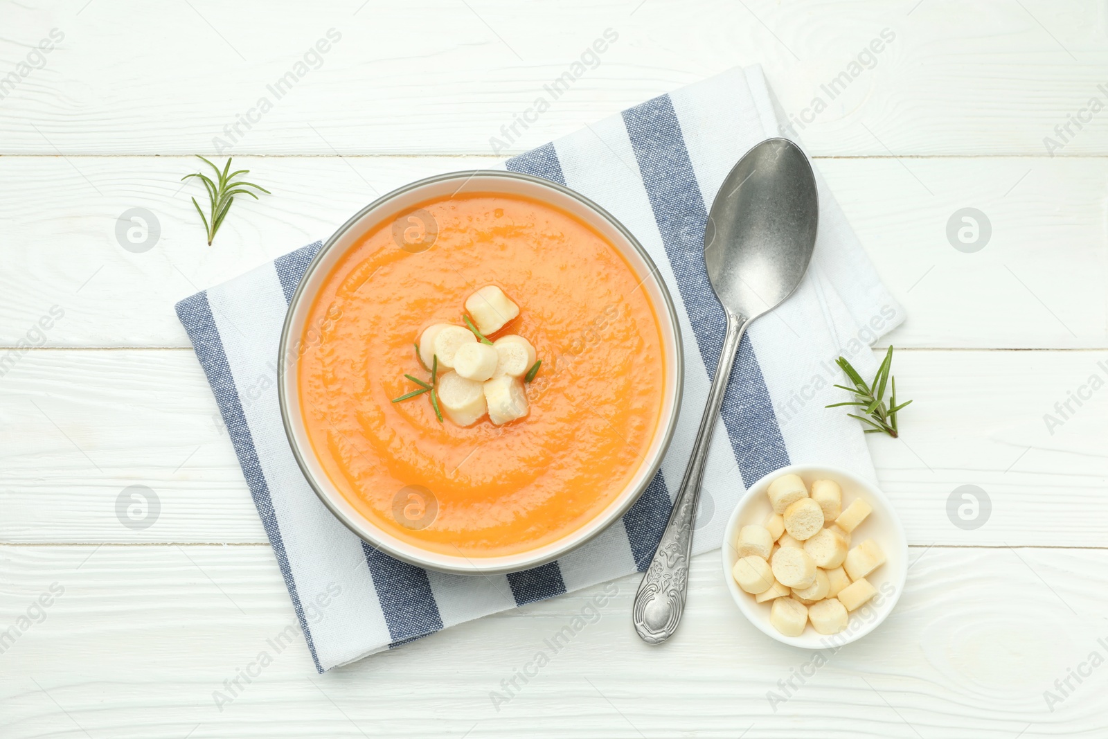 Delicious sweet potato soup with croutons on white wooden table, flat lay Photo of Delicious sweet potato soup with croutons on white wooden table, flat lay