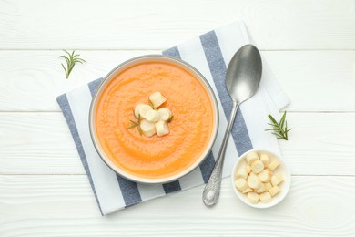 Photo of Delicious sweet potato soup with croutons on white wooden table, flat lay