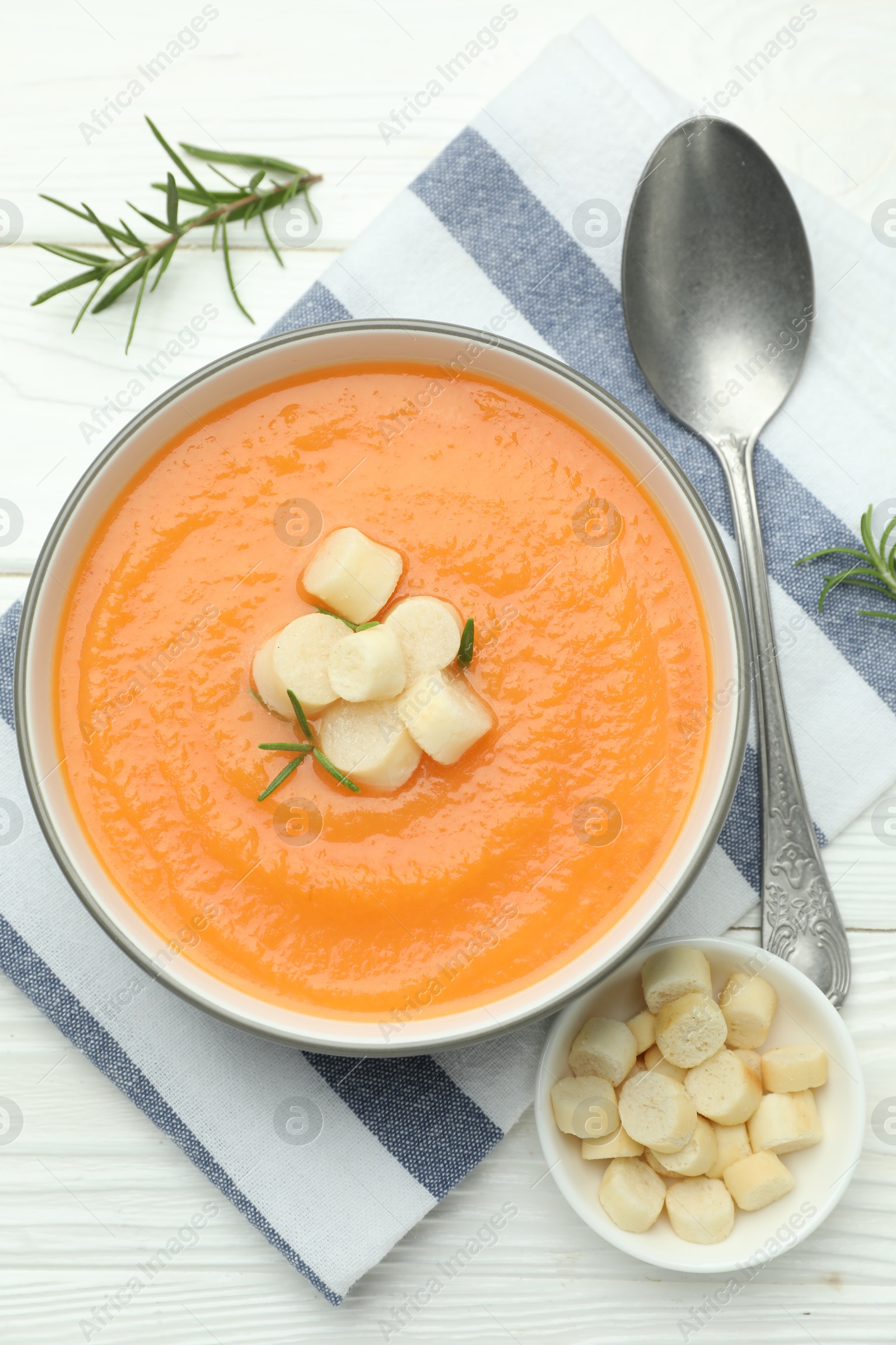 Photo of Delicious sweet potato soup with croutons on white wooden table, flat lay