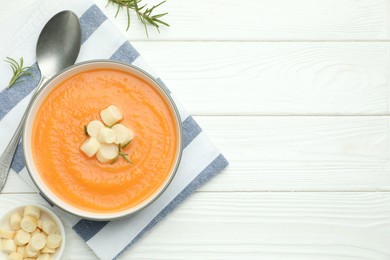 Photo of Delicious sweet potato soup with croutons on white wooden table, flat lay. Space for text