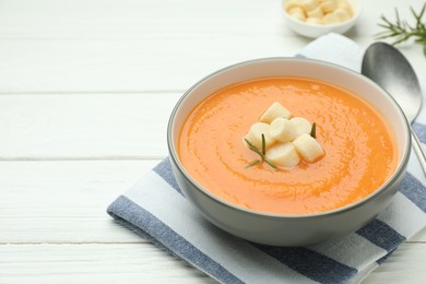 Photo of Delicious sweet potato soup with croutons on white wooden table, closeup. Space for text