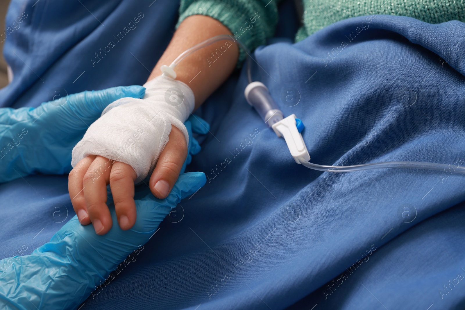 Photo of Doctor and child with IV drip in hospital, closeup