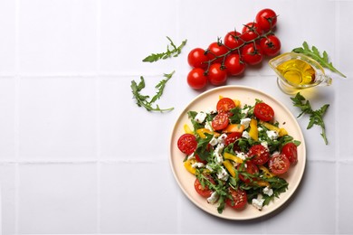 Photo of Tasty salad with arugula, cheese and vegetables on white tiled table, flat lay. Space for text