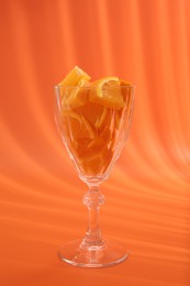 Orange slices in cocktail glass on orange background