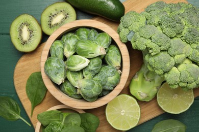 Different fresh healthy products on green wooden table, flat lay