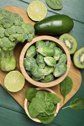 Different fresh healthy products on green wooden table, flat lay