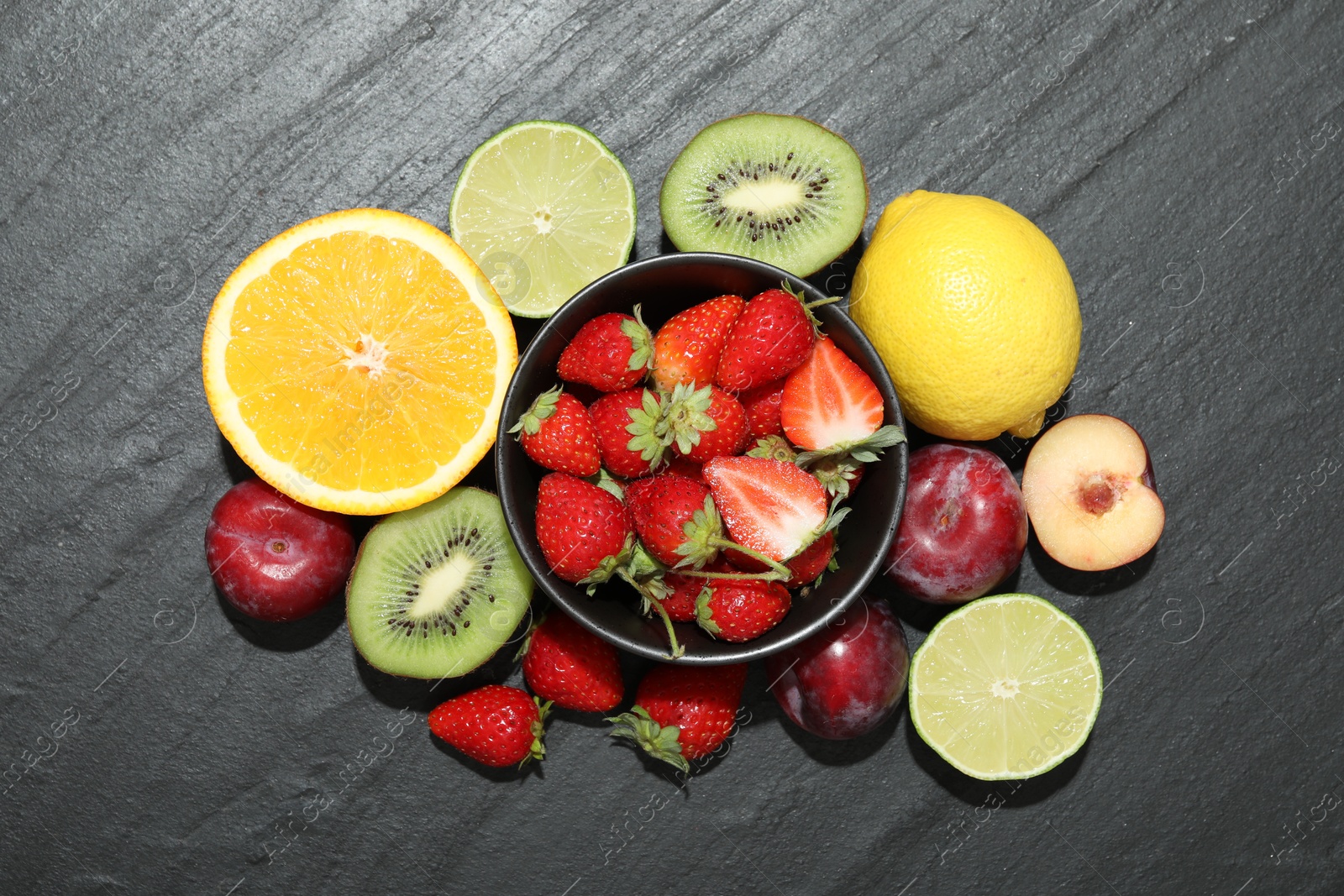 Photo of Different fresh fruits on grey textured table, flat lay