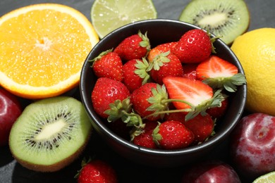 Photo of Different fresh fruits on grey table, closeup