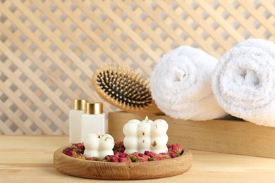 Photo of Composition with towels and cosmetic products for spa treatment on wooden table