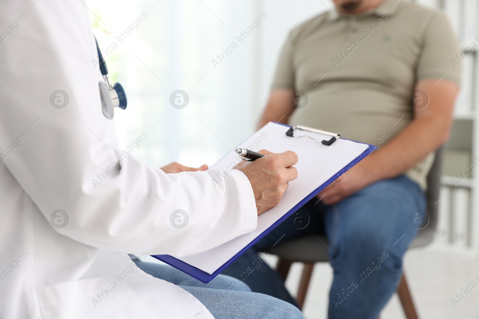 Photo of Nutritionist with clipboard consulting overweight man in clinic, closeup