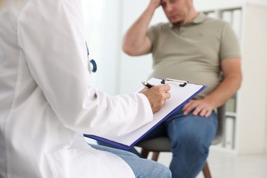 Photo of Nutritionist with clipboard consulting overweight man in clinic, closeup