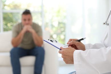 Photo of Overweight man having consultation with nutritionist in clinic, selective focus