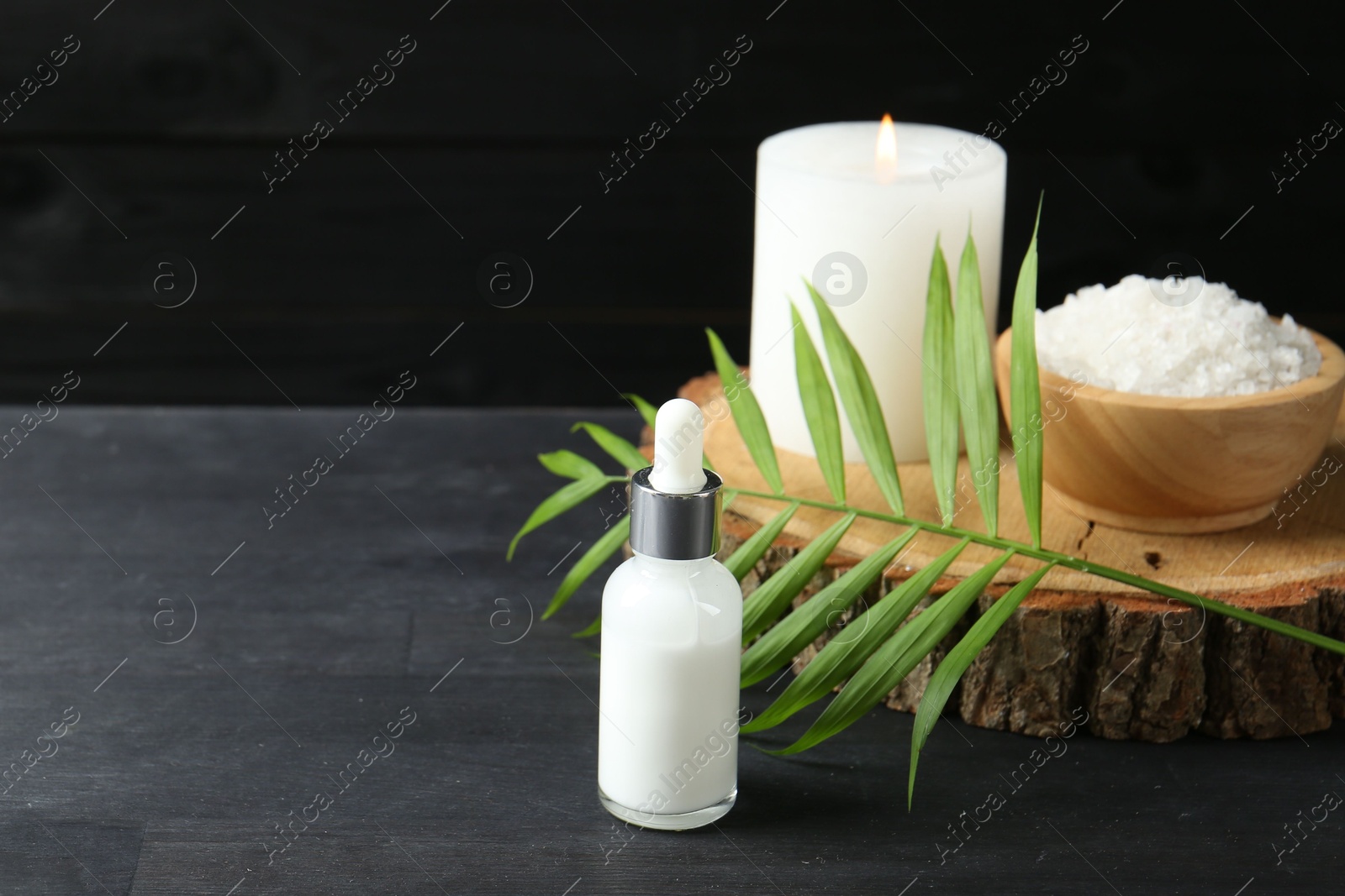 Photo of Composition with cosmetic products for spa treatment on black wooden table, space for text