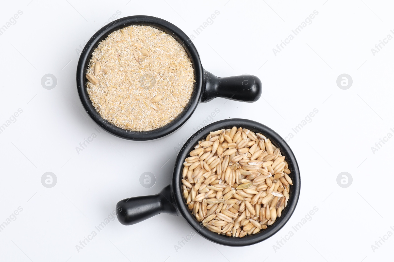 Photo of Oat grains and bran in scoops isolated on white, top view