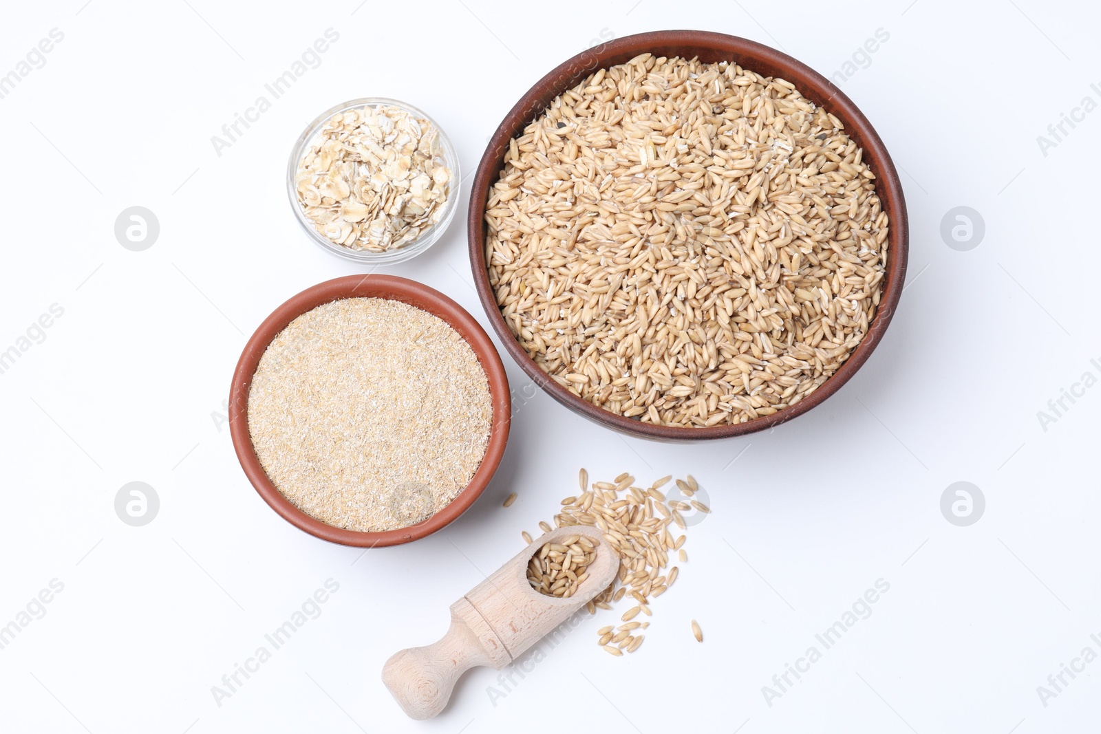 Photo of Oat grains, flakes and bran in bowls isolated on white, top view