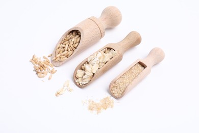 Photo of Scoops with oat grains, flakes and bran isolated on white