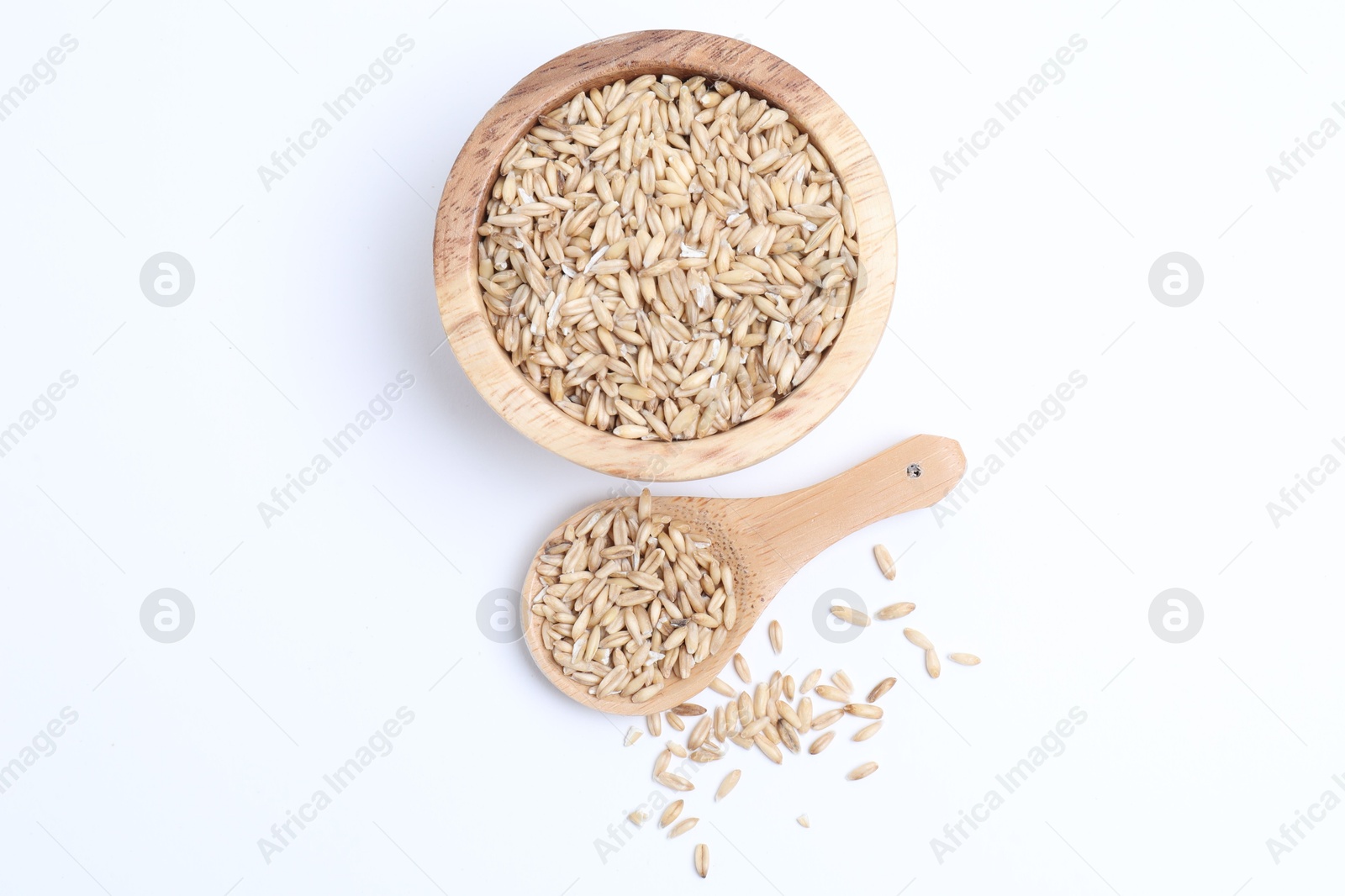 Photo of Oat grains in bowl and spoon isolated on white, top view