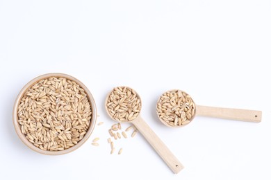 Photo of Oat grains in bowl and spoons isolated on white, top view