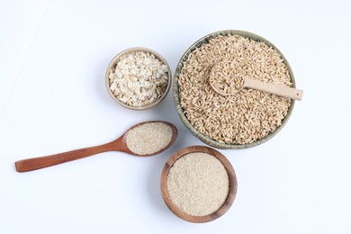 Photo of Oat grains, flakes and bran in bowls isolated on white, top view