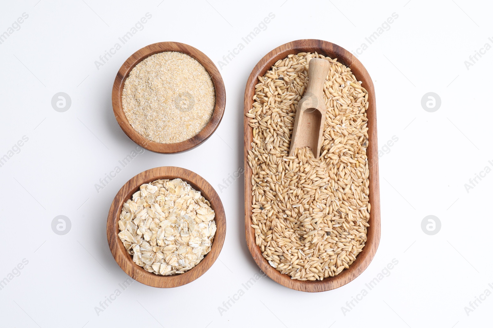 Photo of Oat grains, flakes and bran in dishware isolated on white, top view