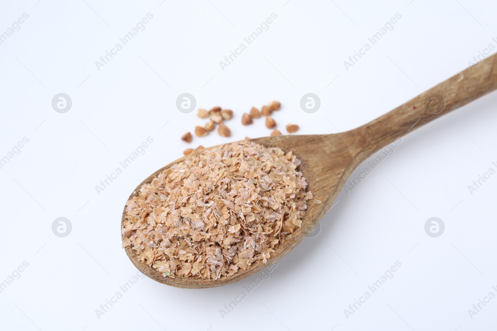 Photo of Buckwheat bran in wooden spoon and grains isolated on white