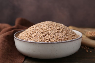 Photo of Buckwheat bran in bowl on wooden table, closeup