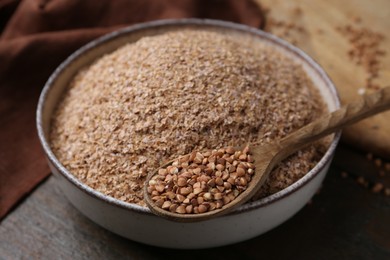 Buckwheat bran in bowl and grains on table, closeup