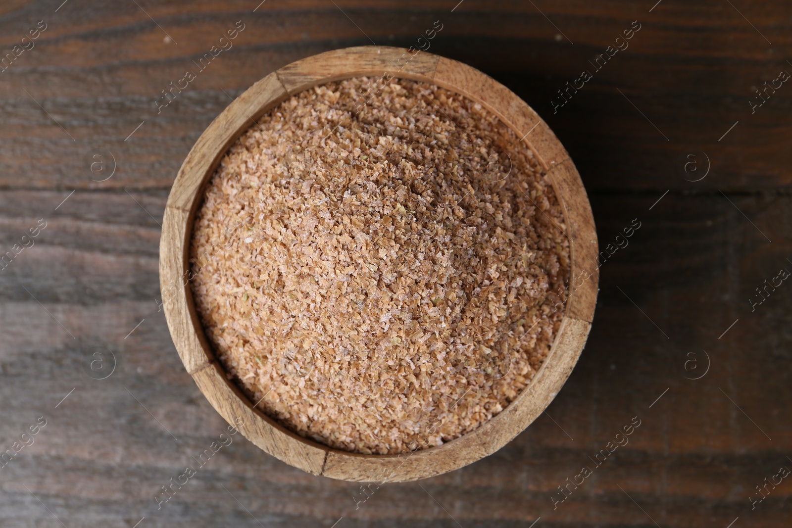 Photo of Buckwheat bran in bowl on wooden table, top view