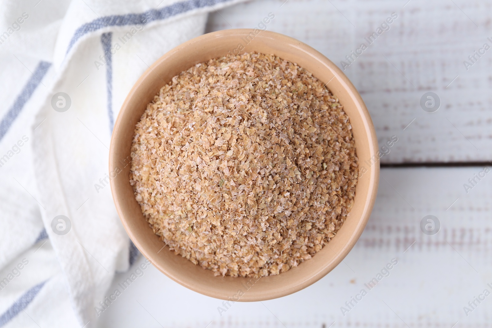 Photo of Buckwheat bran in bowl on white wooden table, top view