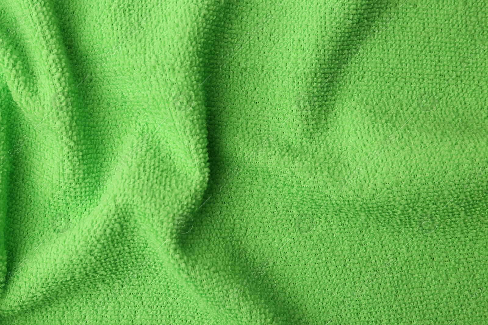 Photo of Clean green microfiber cloth as background, top view