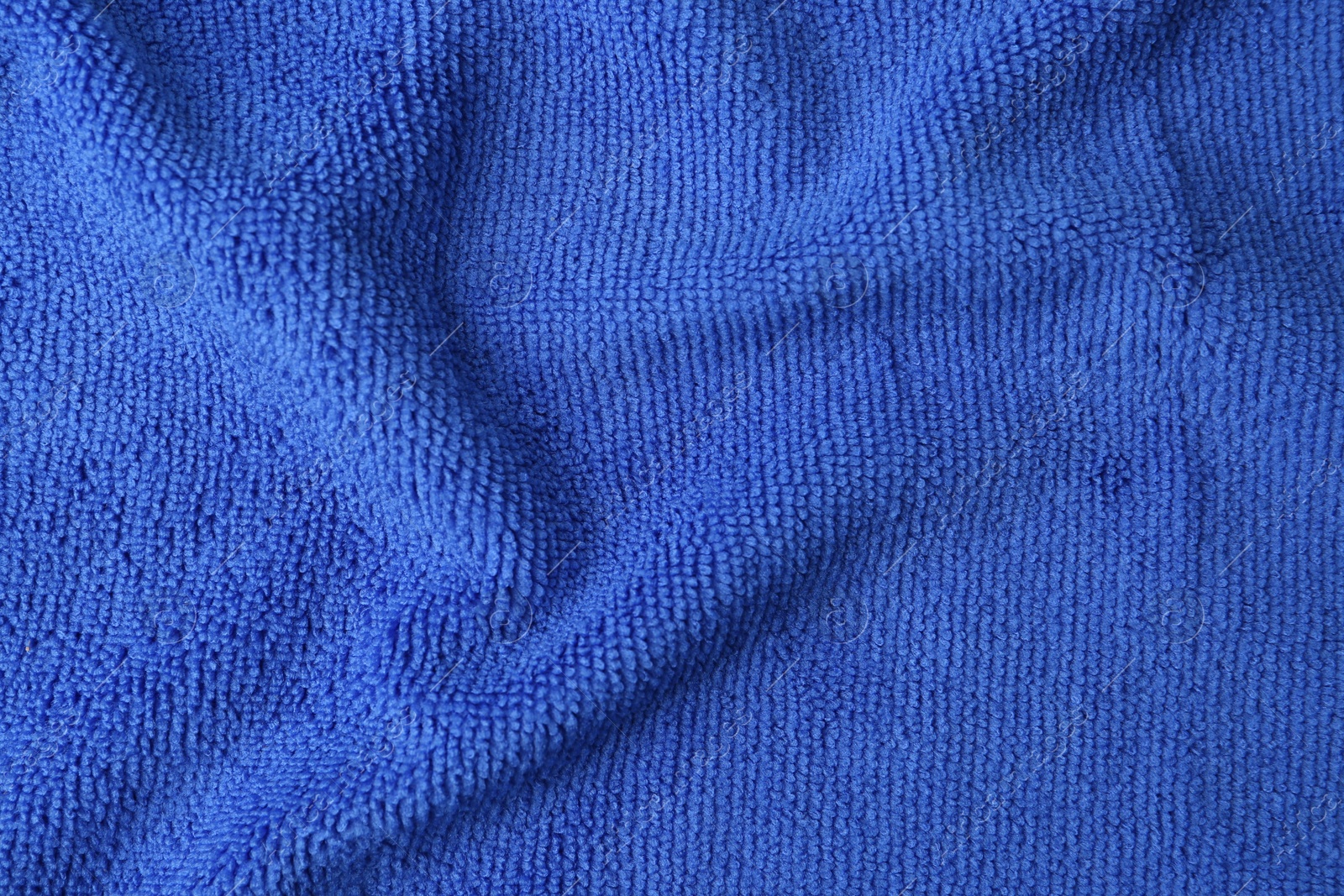 Photo of Clean blue microfiber cloth as background, top view