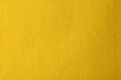 Photo of Clean yellow microfiber cloth as background, top view