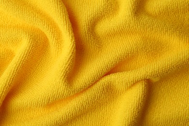 Clean yellow microfiber cloth as background, top view