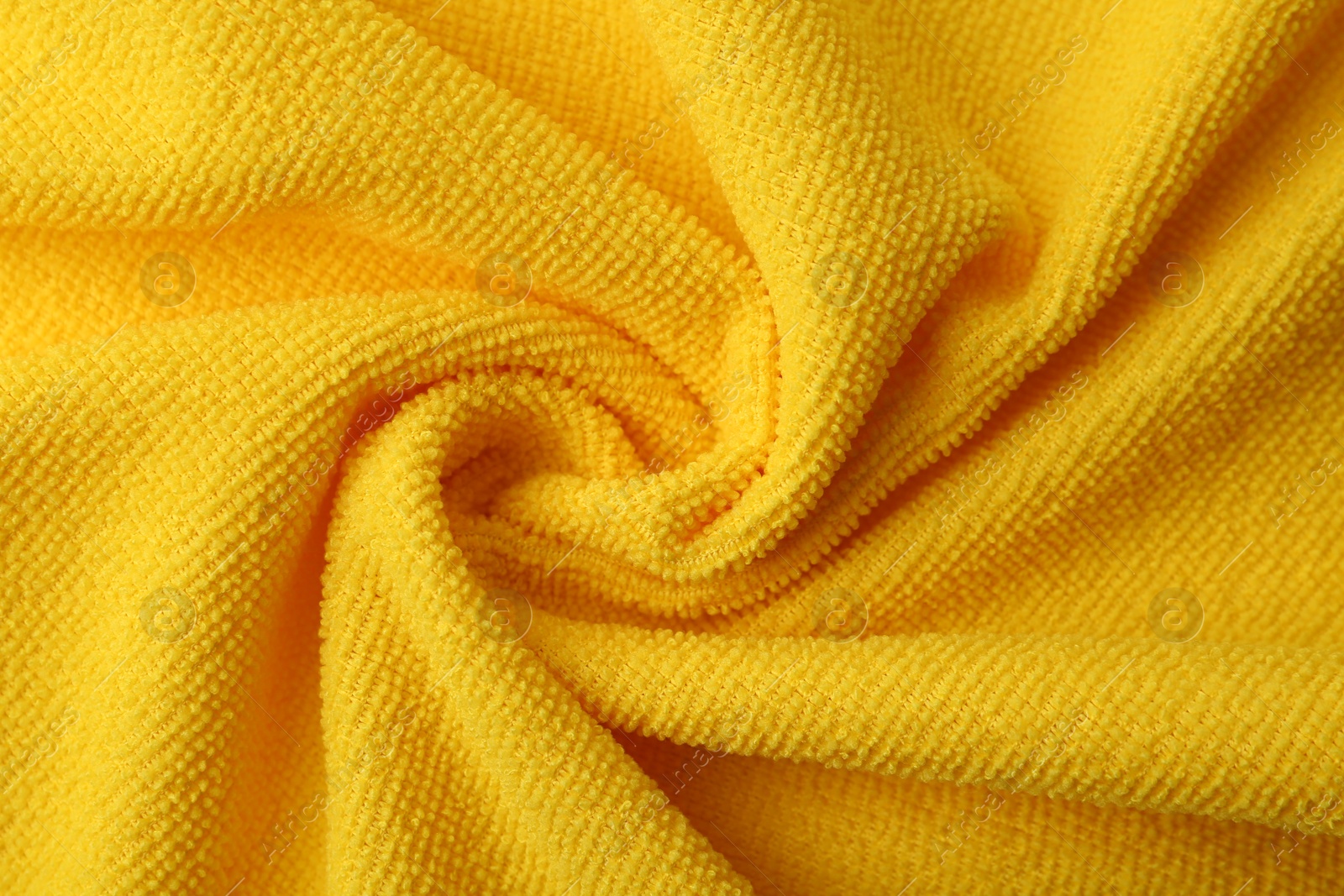 Photo of Clean yellow microfiber cloth as background, top view