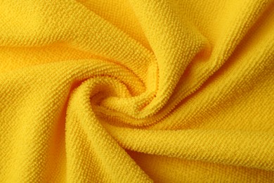 Photo of Clean yellow microfiber cloth as background, top view