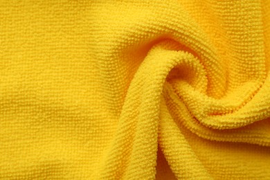 Photo of Clean yellow microfiber cloth as background, top view