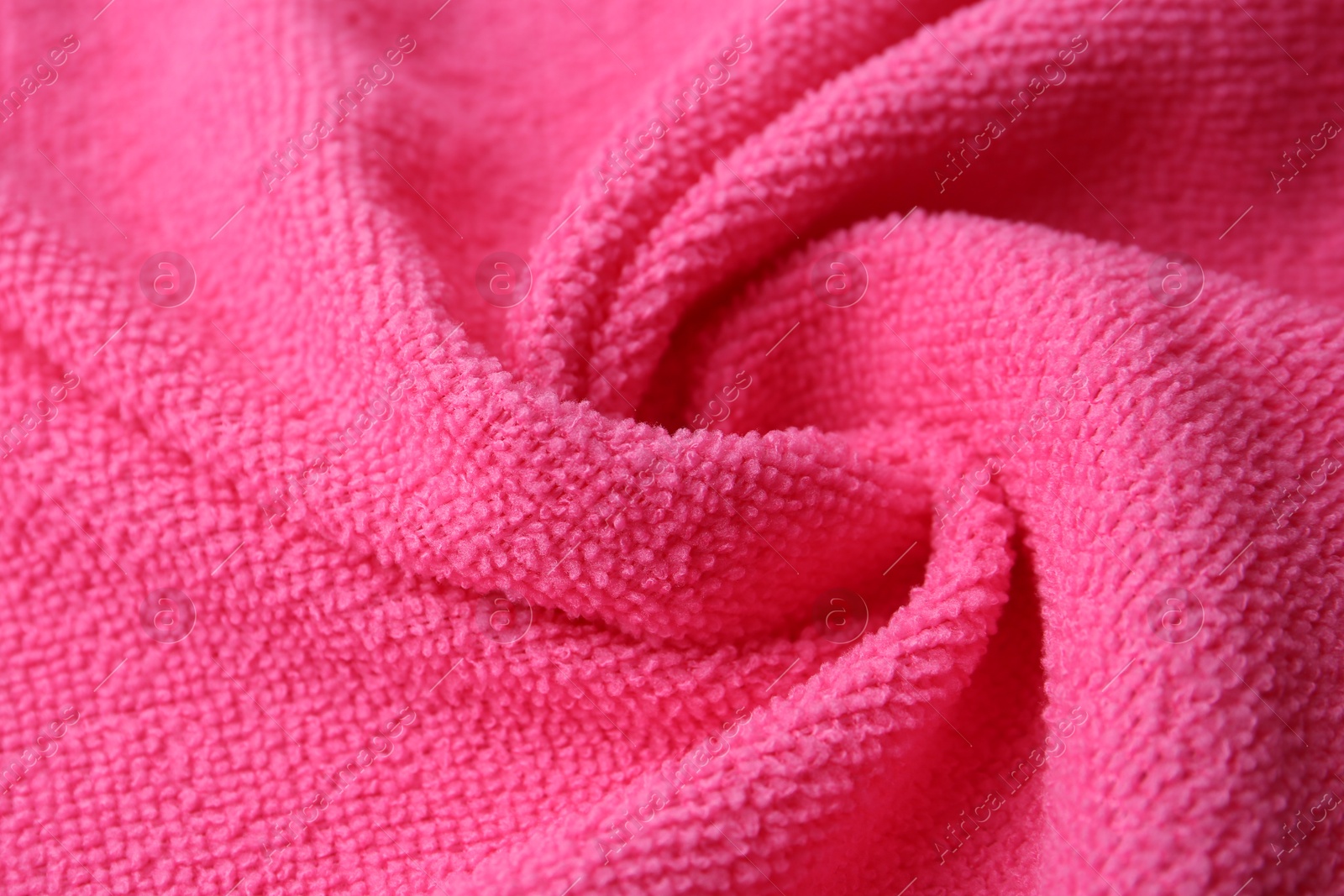 Photo of Clean pink microfiber cloth as background, closeup