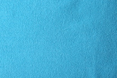 Photo of Clean light blue microfiber cloth as background, top view