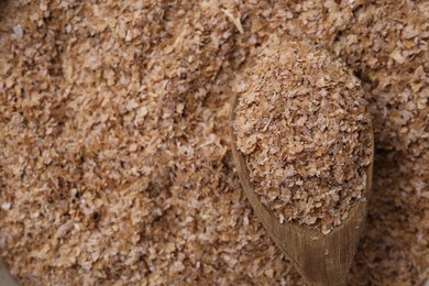 Photo of Pile of buckwheat bran and wooden spoon, above view