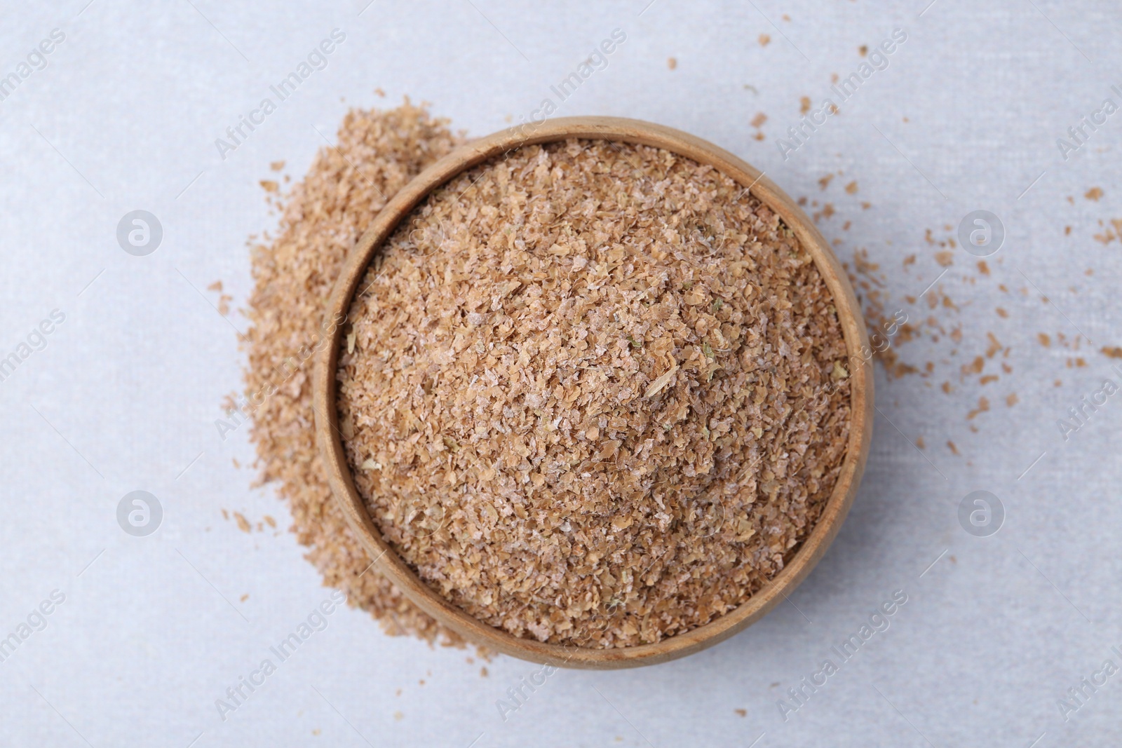 Photo of Buckwheat bran in bowl on light grey table, top view