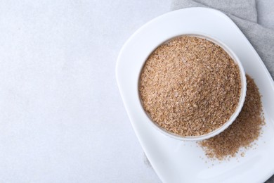 Photo of Buckwheat bran in bowl on light grey table, top view. Space for text