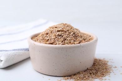 Photo of Buckwheat bran in bowl on white table, closeup