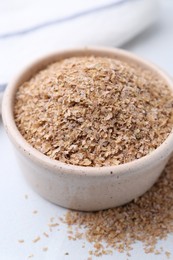 Photo of Buckwheat bran in bowl on white table, closeup