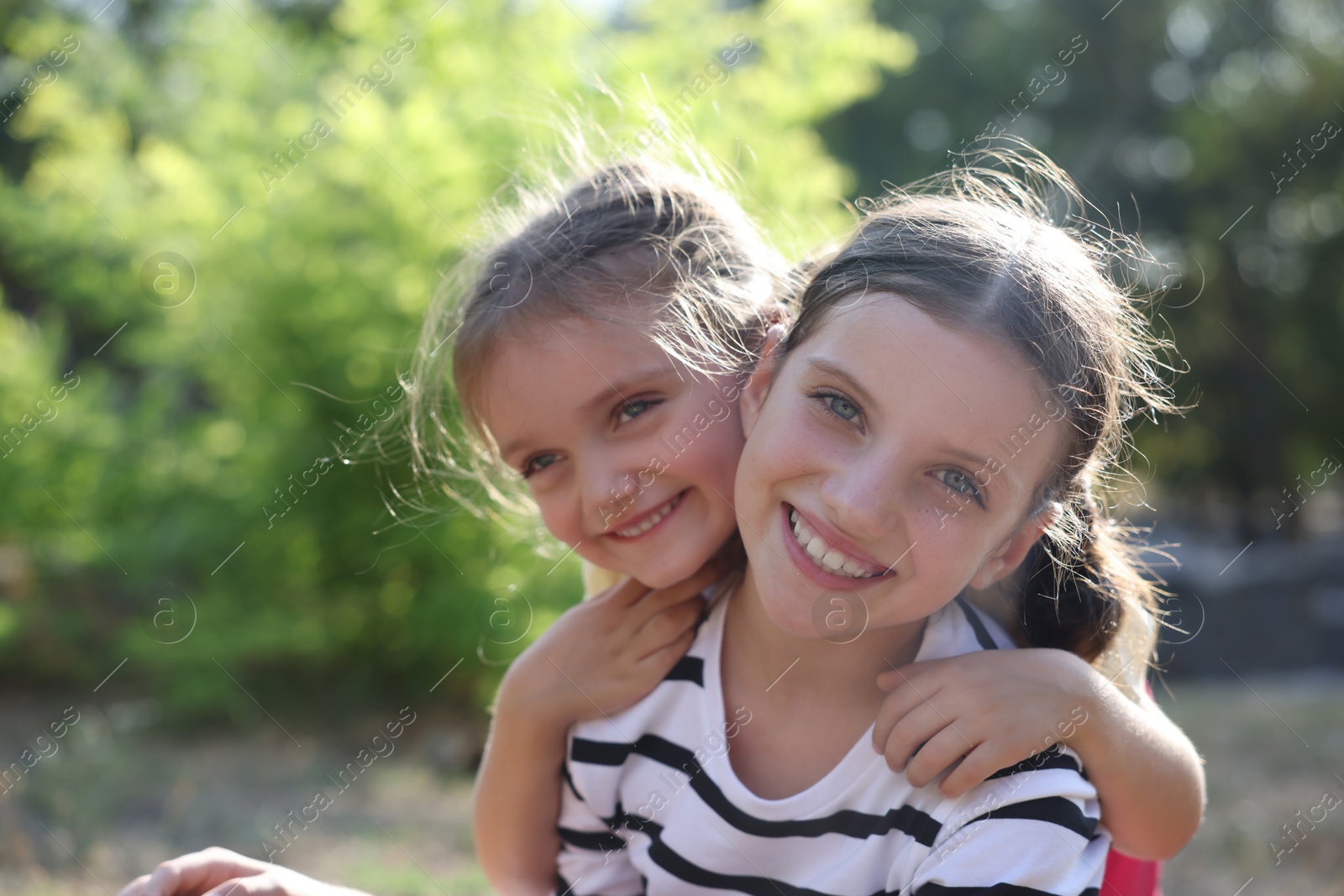 Photo of Portrait of cute little sisters in park