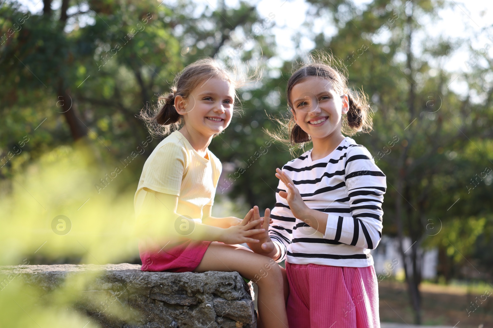 Photo of Portrait of cute little sisters in park