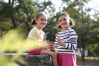 Portrait of cute little sisters in park