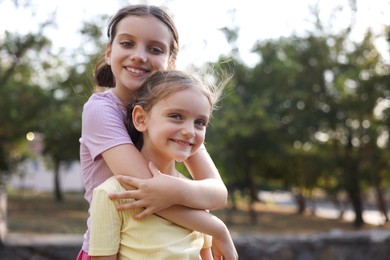 Photo of Portrait of cute little sisters in park