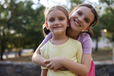 Photo of Portrait of cute little sisters in park